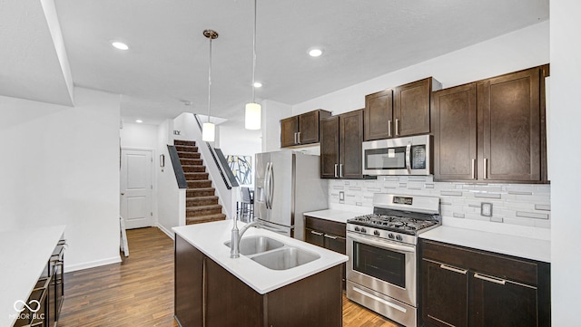 9717 Chuckwalla Pl, Fishers, IN 46040 - kitchen with appliances with stainless steel finishes, a sink, dark wood-style flooring, decorative backsplash, and dark brown cabinetry