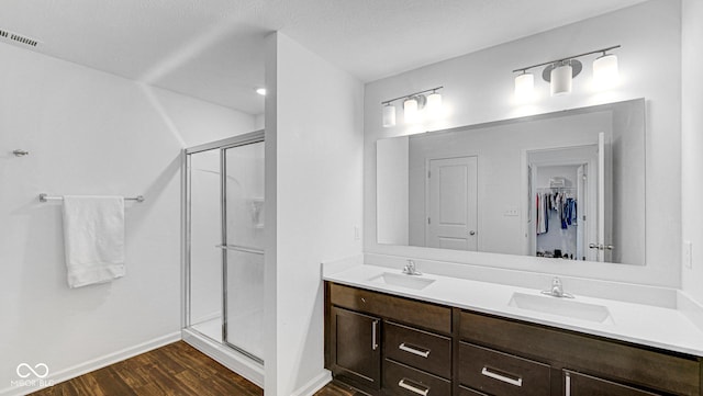 9717 Chuckwalla Pl, Fishers, IN 46040 - full bathroom featuring wood finished floors, a stall shower, double vanity, baseboards, and a spacious closet
