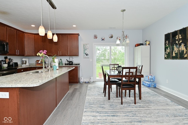 2330 Oak Dr, Clayton, IN 46118 - kitchen featuring light wood-style flooring, black appliances, a sink, light stone countertops, and recessed lighting