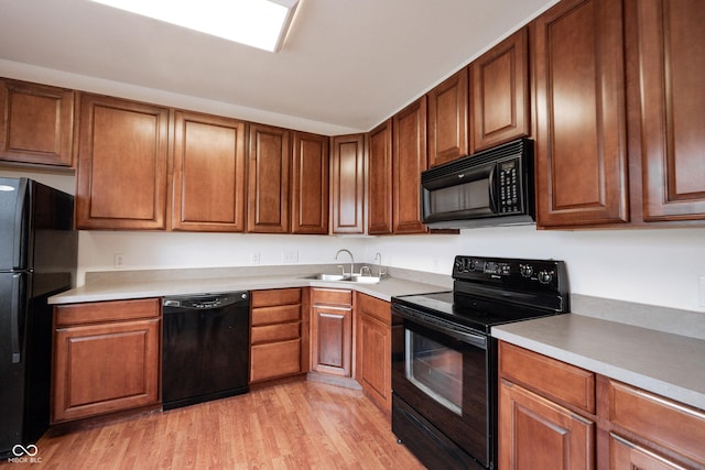 9117 Thoreau Ct, Fishers, IN 46037 - kitchen featuring black appliances, a sink, light wood finished floors, and light countertops