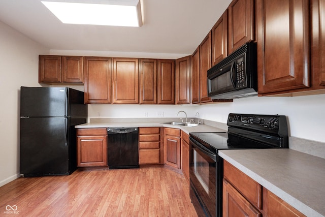 9117 Thoreau Ct, Fishers, IN 46037 - kitchen with black appliances, a sink, light wood-style floors, light countertops, and brown cabinetry