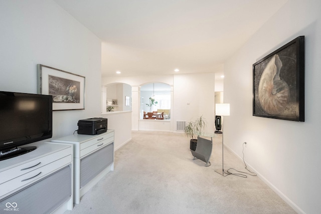 9117 Thoreau Ct, Fishers, IN 46037 - living area featuring arched walkways, light carpet, ornate columns, recessed lighting, and baseboards