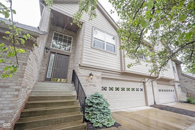 9117 Thoreau Ct, Fishers, IN 46037 - view of front of property with an attached garage, brick siding, driveway, and entry steps