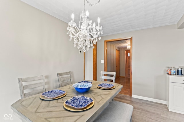 2137 W Bobwhite Dr, Scottsburg, IN 47170 - dining room featuring a chandelier, wood finished floors, and baseboards