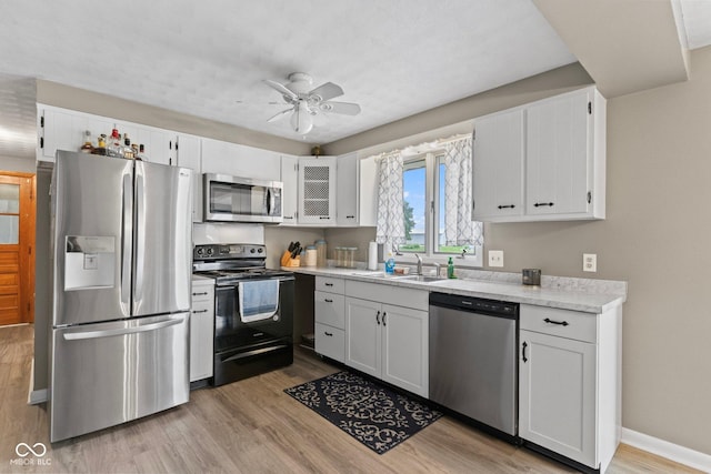 2137 W Bobwhite Dr, Scottsburg, IN 47170 - kitchen featuring appliances with stainless steel finishes, a sink, light wood-type flooring, ceiling fan, and white cabinetry