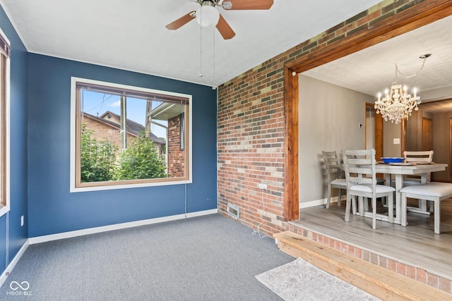 2137 W Bobwhite Dr, Scottsburg, IN 47170 - carpeted dining room with baseboards, a chandelier, a ceiling fan, and brick wall