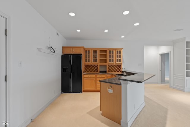 11065 Spice Ln, Fishers, IN 46037 - kitchen with black fridge, dark countertops, light colored carpet, a peninsula, and recessed lighting