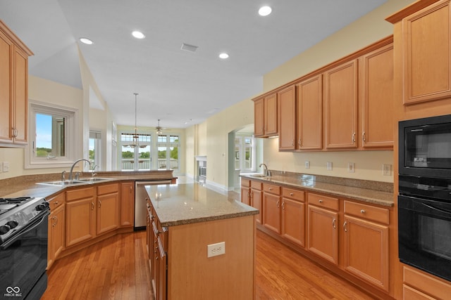 11065 Spice Ln, Fishers, IN 46037 - kitchen with black appliances, light wood-style flooring, a kitchen island, recessed lighting, and a peninsula