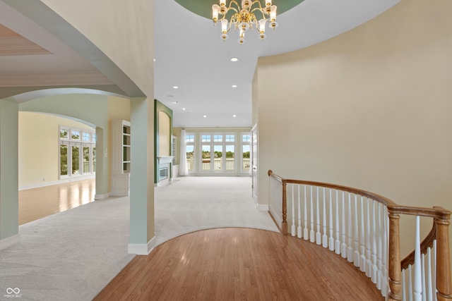 11065 Spice Ln, Fishers, IN 46037 - corridor featuring light colored carpet, a chandelier, arched walkways, recessed lighting, and light wood-type flooring