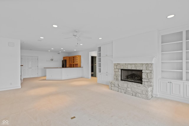 11065 Spice Ln, Fishers, IN 46037 - unfurnished living room featuring a stone fireplace, ceiling fan, light carpet, recessed lighting, and built in features