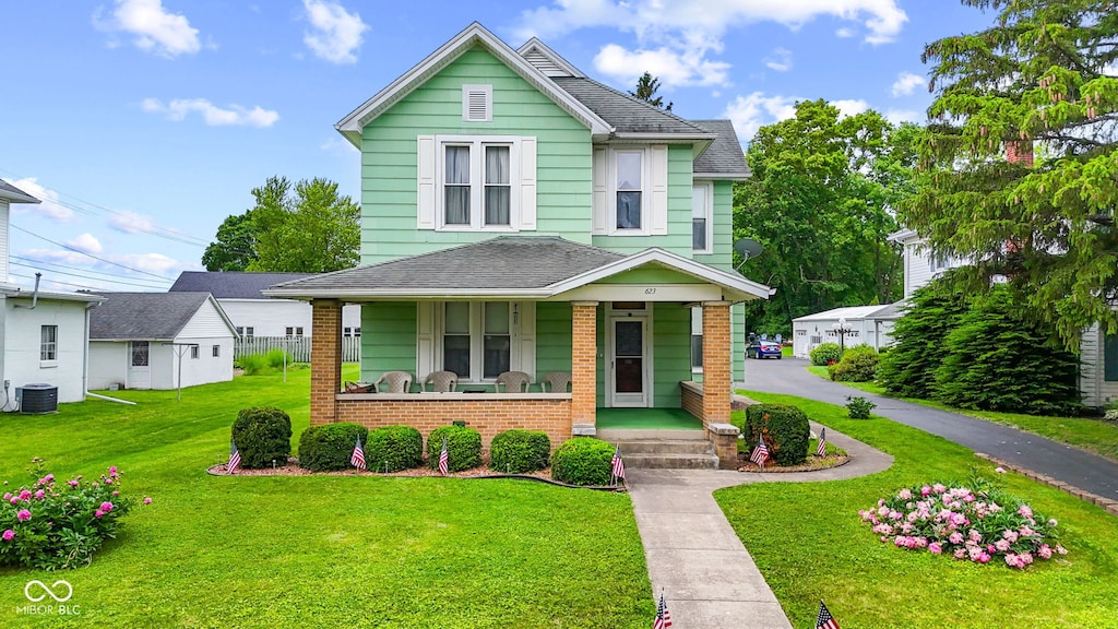 623 E Main St, Greensburg, IN 47240 - view of front of property featuring a porch, brick siding, a front yard, central AC, and roof with shingles