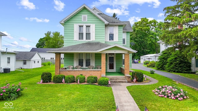 623 E Main St, Greensburg, IN 47240 - view of front of property featuring a porch, brick siding, a front yard, central AC, and roof with shingles
