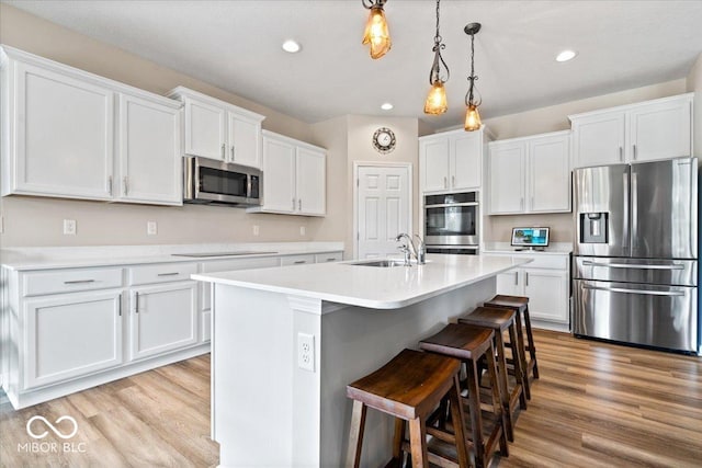 1539 Hazy Falls Blvd, Westfield, IN 46074 - kitchen featuring stainless steel appliances, a sink, white cabinets, light countertops, and light wood-type flooring