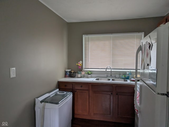 13 Thomas St, North Vernon, IN 47265 - kitchen with freestanding refrigerator, a sink, crown molding, light countertops, and brown cabinets