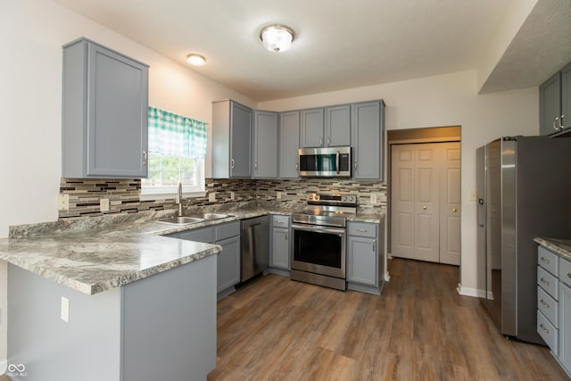 3623 Carroll Farms Dr, Indianapolis, IN 46235 - kitchen featuring appliances with stainless steel finishes, a sink, gray cabinetry, a peninsula, and tasteful backsplash