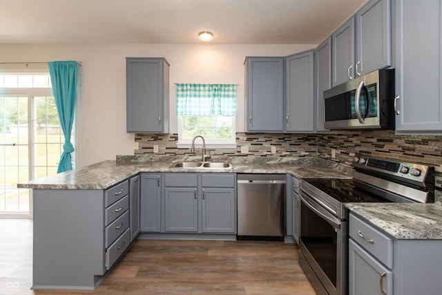 3623 Carroll Farms Dr, Indianapolis, IN 46235 - kitchen with appliances with stainless steel finishes, a sink, gray cabinets, and a peninsula