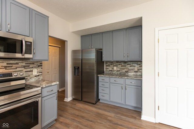 3623 Carroll Farms Dr, Indianapolis, IN 46235 - kitchen with appliances with stainless steel finishes, gray cabinets, decorative backsplash, and dark wood-style flooring