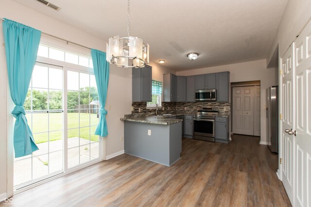 3623 Carroll Farms Dr, Indianapolis, IN 46235 - kitchen with stainless steel appliances, gray cabinets, a chandelier, tasteful backsplash, and wood finished floors