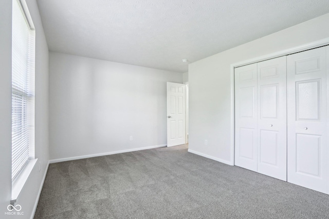 12250 Longstraw Dr, Indianapolis, IN 46236 - unfurnished bedroom featuring carpet flooring, multiple windows, a closet, and baseboards