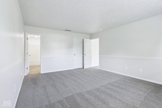 12250 Longstraw Dr, Indianapolis, IN 46236 - unfurnished bedroom with a textured ceiling, carpet, baseboards, and connected bathroom