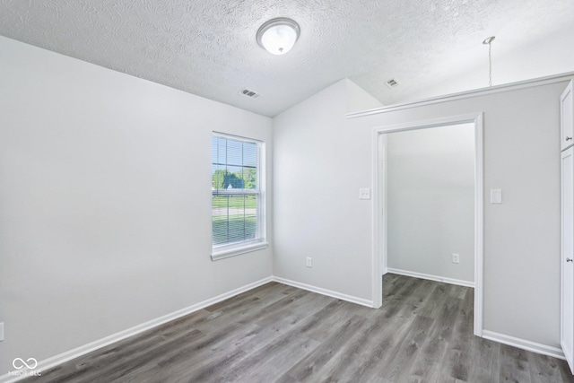 12250 Longstraw Dr, Indianapolis, IN 46236 - unfurnished bedroom with vaulted ceiling, wood finished floors, a textured ceiling, and baseboards