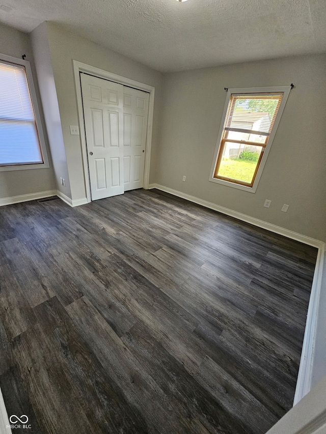 315 Schoolhouse Rd, Franklin, IN 46131 - unfurnished bedroom featuring dark wood-style floors, a textured ceiling, baseboards, and a closet