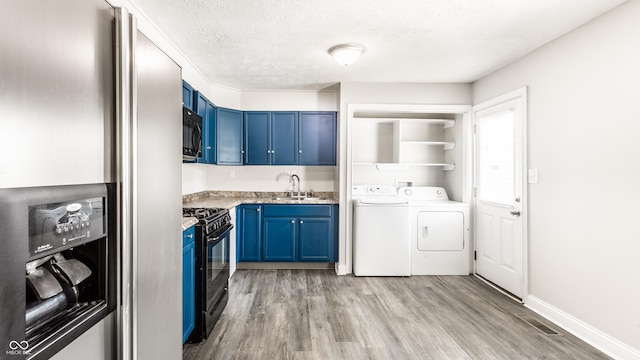 315 Schoolhouse Rd, Franklin, IN 46131 - laundry room with washer and dryer, light wood-style floors, and a textured ceiling