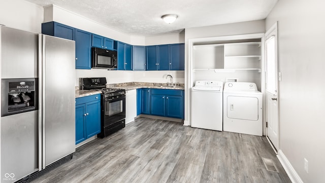 315 Schoolhouse Rd, Franklin, IN 46131 - kitchen featuring black appliances, blue cabinetry, washing machine and clothes dryer, light wood-type flooring, and a sink