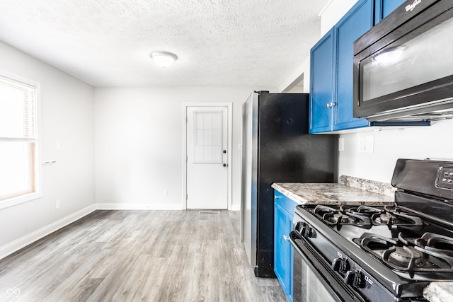 315 Schoolhouse Rd, Franklin, IN 46131 - kitchen with range with gas stovetop, black microwave, blue cabinetry, and a textured ceiling