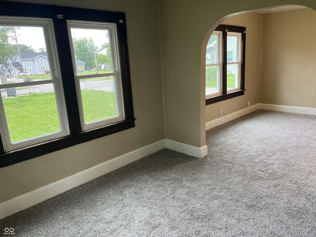 1020 E 30th St, Anderson, IN 46016 - carpeted empty room with plenty of natural light, baseboards, and arched walkways