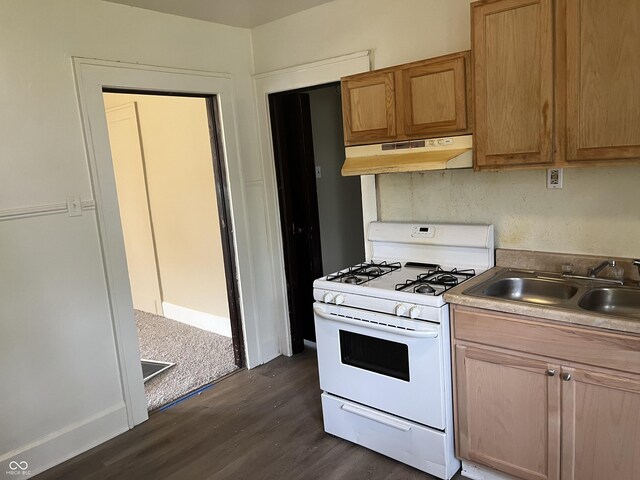 1020 E 30th St, Anderson, IN 46016 - kitchen with under cabinet range hood, white range with gas stovetop, a sink, and dark wood finished floors