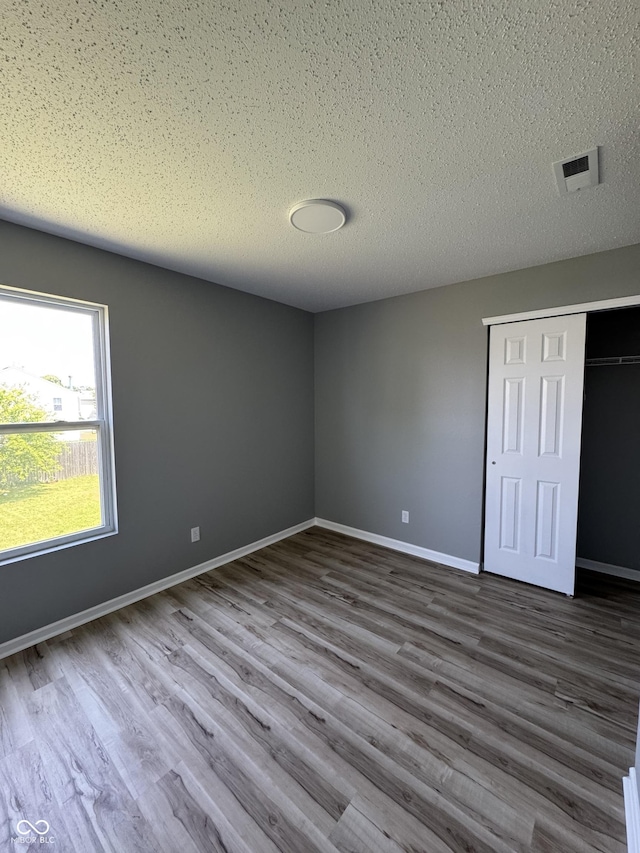 3327 Brandenburg Blvd, Indianapolis, IN 46239 - unfurnished bedroom with dark wood-type flooring, a closet, baseboards, and a textured ceiling