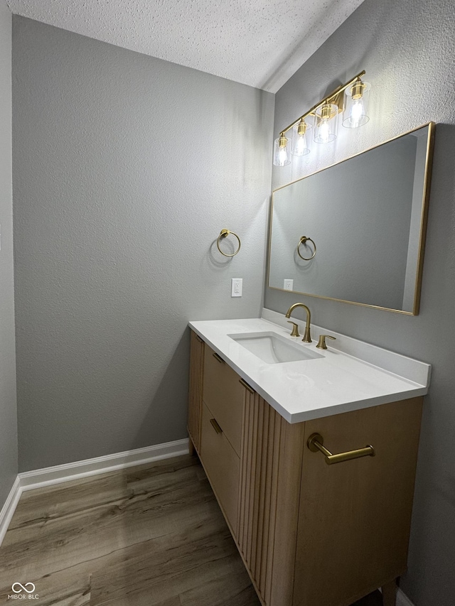 3327 Brandenburg Blvd, Indianapolis, IN 46239 - bathroom with vanity, wood finished floors, baseboards, and a textured ceiling