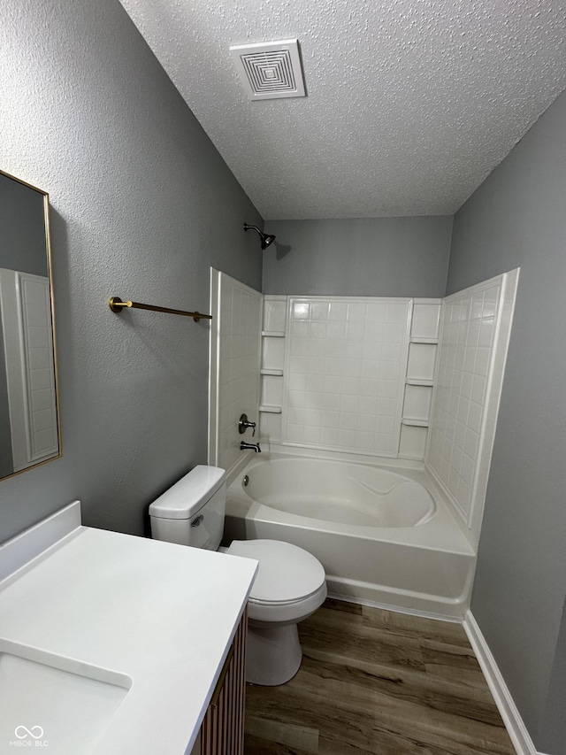 3327 Brandenburg Blvd, Indianapolis, IN 46239 - bathroom featuring wood finished floors, toilet, a textured ceiling, vanity, and shower / washtub combination