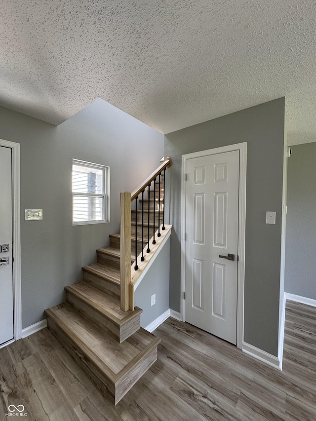 3327 Brandenburg Blvd, Indianapolis, IN 46239 - staircase with a textured ceiling, wood finished floors, and baseboards