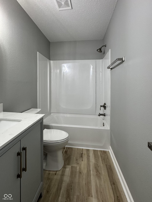 3327 Brandenburg Blvd, Indianapolis, IN 46239 - full bathroom with wood finished floors, vanity, toilet, a textured ceiling, and shower / washtub combination