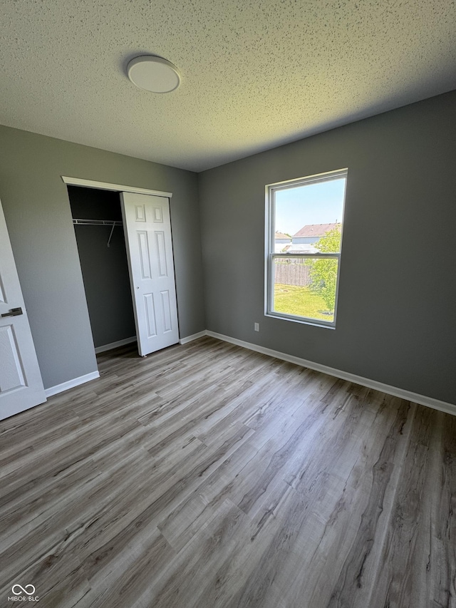 3327 Brandenburg Blvd, Indianapolis, IN 46239 - unfurnished bedroom featuring a closet, wood finished floors, baseboards, and a textured ceiling