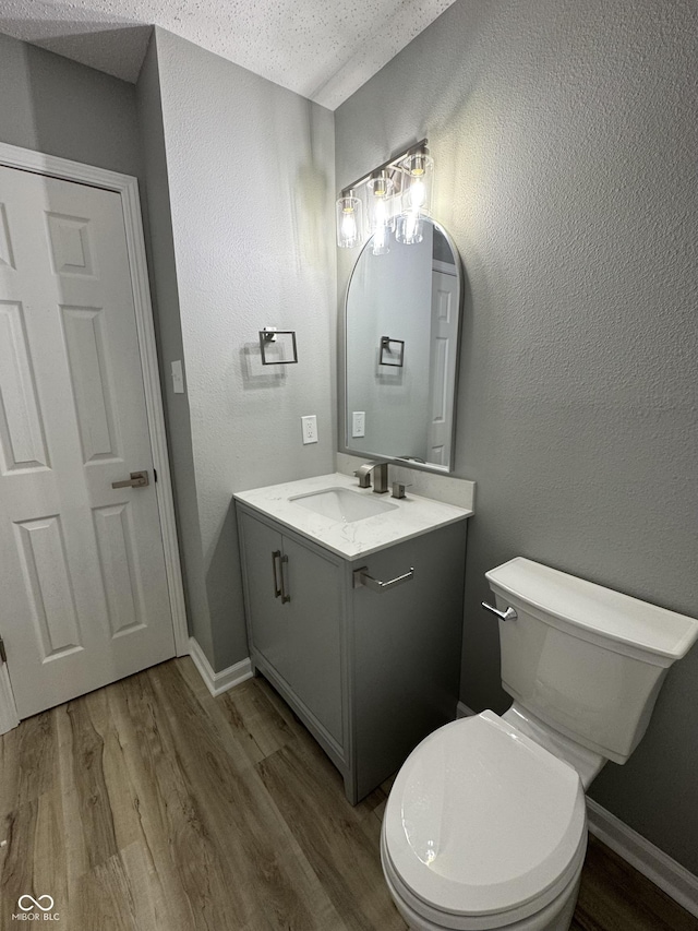 3327 Brandenburg Blvd, Indianapolis, IN 46239 - bathroom with vanity, wood finished floors, a textured ceiling, toilet, and a textured wall