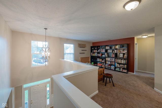 13271 Aquamarine Dr, Carmel, IN 46033 - hallway featuring a chandelier, an upstairs landing, carpet floors, and a textured ceiling
