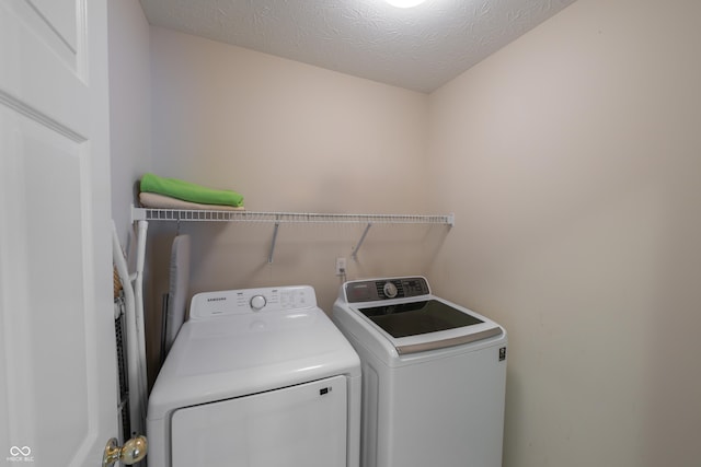 13271 Aquamarine Dr, Carmel, IN 46033 - laundry room with washing machine and clothes dryer and a textured ceiling