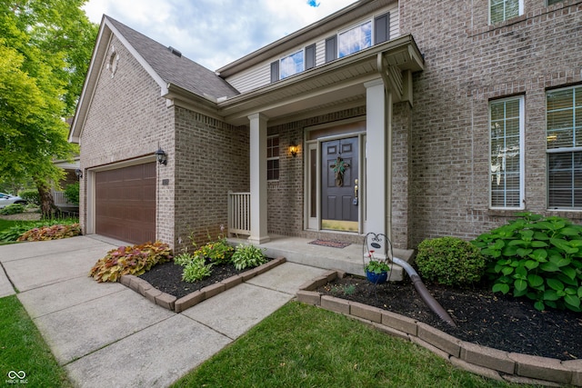 13271 Aquamarine Dr, Carmel, IN 46033 - property entrance with an attached garage, brick siding, and driveway