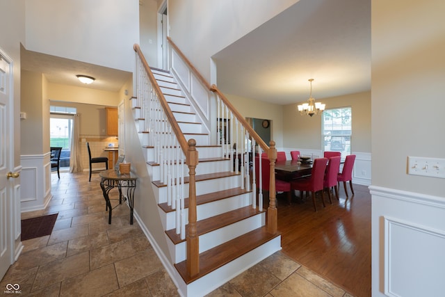 13271 Aquamarine Dr, Carmel, IN 46033 - stairway featuring a chandelier, healthy amount of natural light, wainscoting, and a decorative wall
