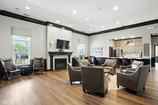 17233 Gunther Blvd Unit 102B, Westfield, IN 46074 - living area with ornamental molding, healthy amount of natural light, a fireplace with flush hearth, light wood finished floors, and recessed lighting