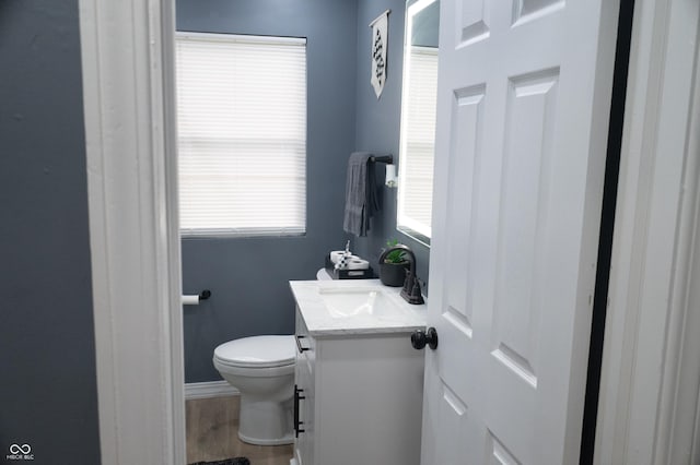 1331 N Berwick Ave, Indianapolis, IN 46222 - half bathroom with vanity, toilet, baseboards, and wood finished floors