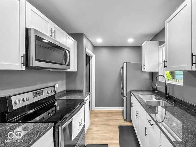 1331 N Berwick Ave, Indianapolis, IN 46222 - kitchen featuring appliances with stainless steel finishes, white cabinets, dark stone countertops, recessed lighting, and light wood-style floors
