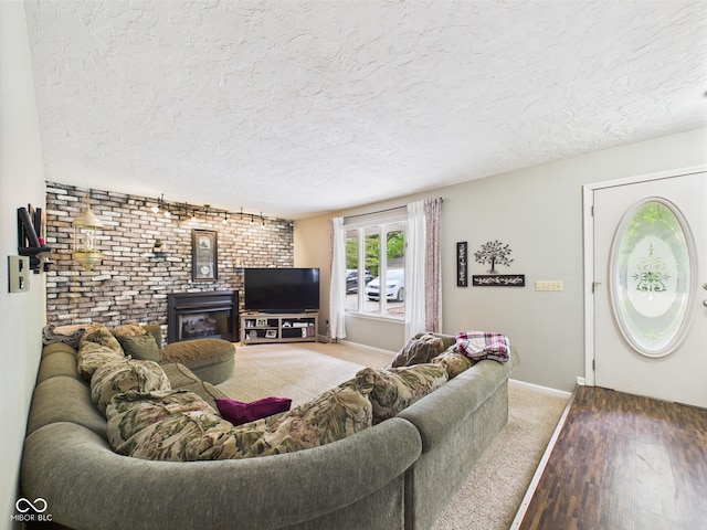 5542 N Olivia Dr, Alexandria, IN 46001 - living room with wood finished floors, a textured ceiling, brick wall, baseboards, and a wood stove