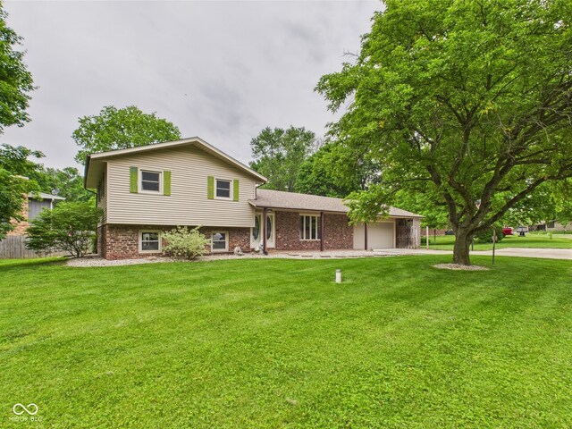5542 N Olivia Dr, Alexandria, IN 46001 - split level home featuring a garage, a front yard, and brick siding