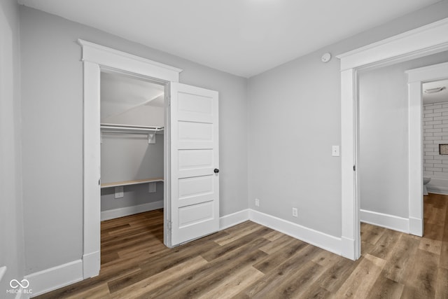 3227 Guilford Ave, Indianapolis, IN 46205 - unfurnished bedroom with a spacious closet, wood finished floors, a closet, and baseboards