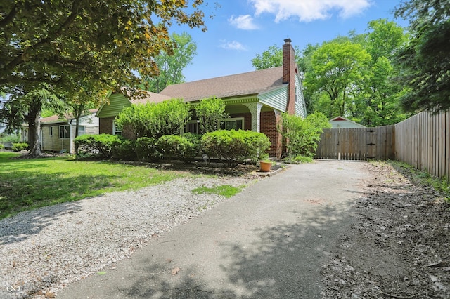 2905 N Warman Ave, Indianapolis, IN 46222 - view of front of home featuring asphalt driveway, brick siding, a chimney, and a gate