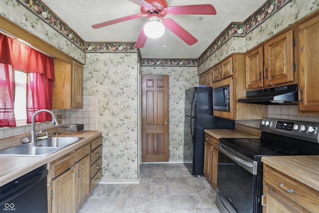 2905 N Warman Ave, Indianapolis, IN 46222 - kitchen featuring black appliances, a sink, under cabinet range hood, wallpapered walls, and baseboards